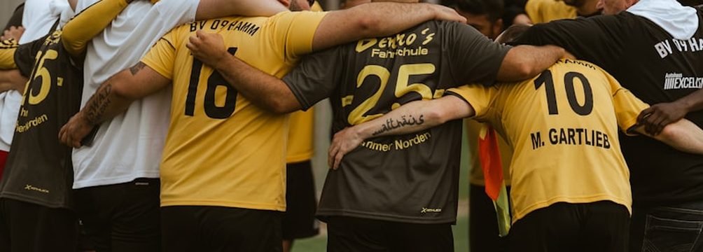 Jugadoras de un equipo amateur reunidas en piña sobre el campo antes del partido.
