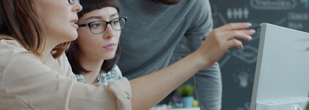 Equipo de trabajo señalando una pantalla mientras valora una aplicación.